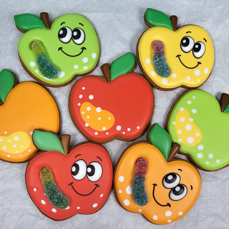Cute apple cookies with smiling faces and colorful icing details
