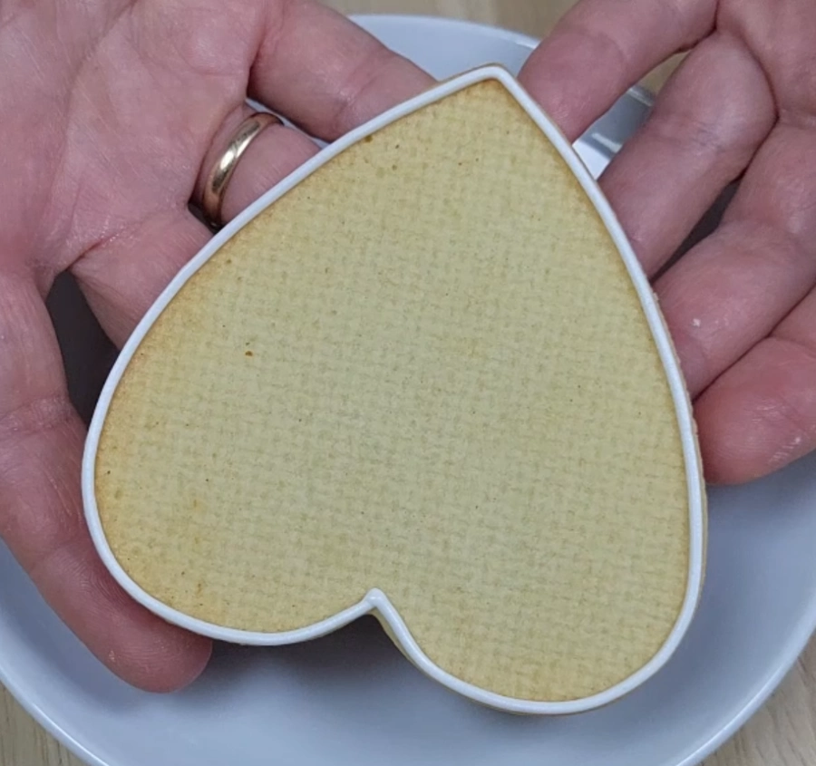 Royal icing outline drying on a cookie