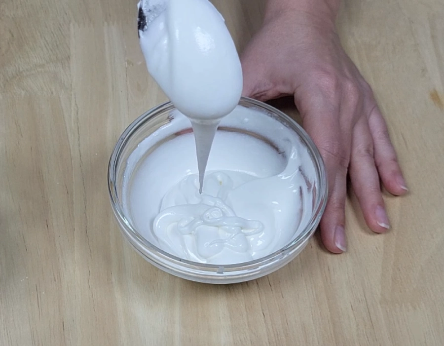 Royal icing medium consistency flowing in a wide ribbon